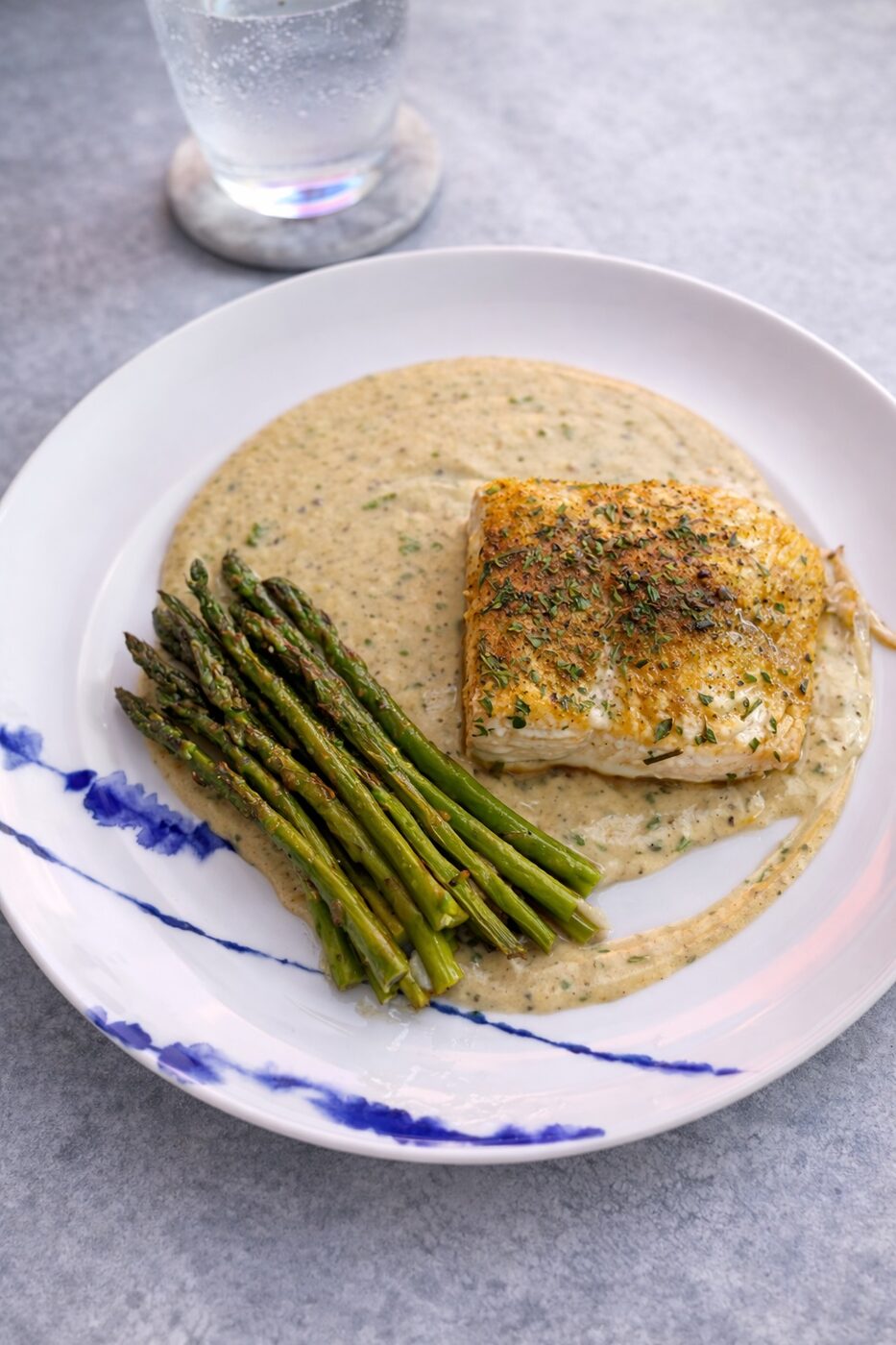 Herb-crusted white fish over cream sauce with fresh asparagus — weekly meal prep Alpharetta GA